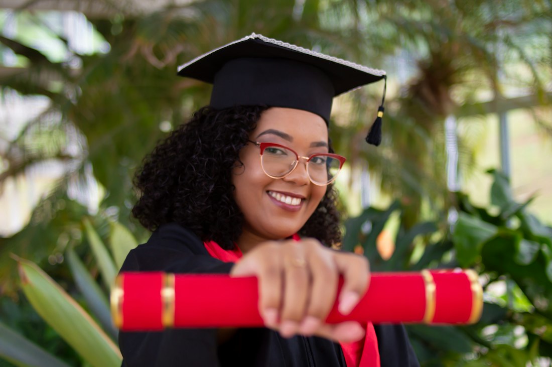 Estudiante sonriente con toga y birrete de graduación